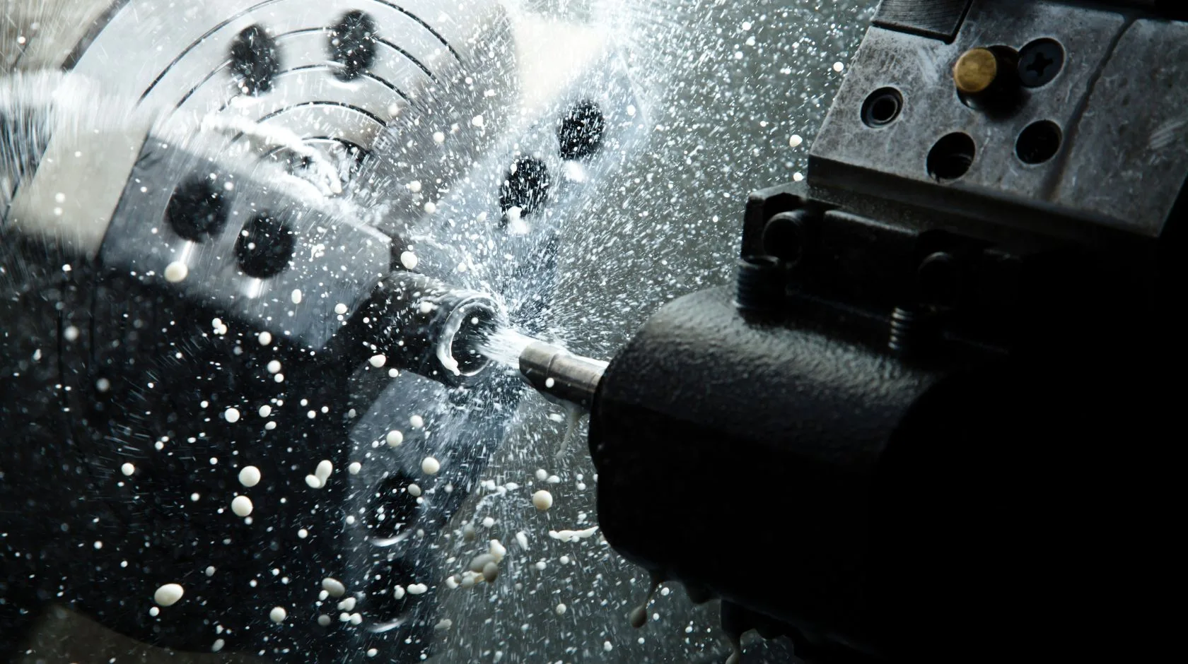 CNC machine in action with coolant spray, reflecting Axinar’s commitment to innovation and precision
