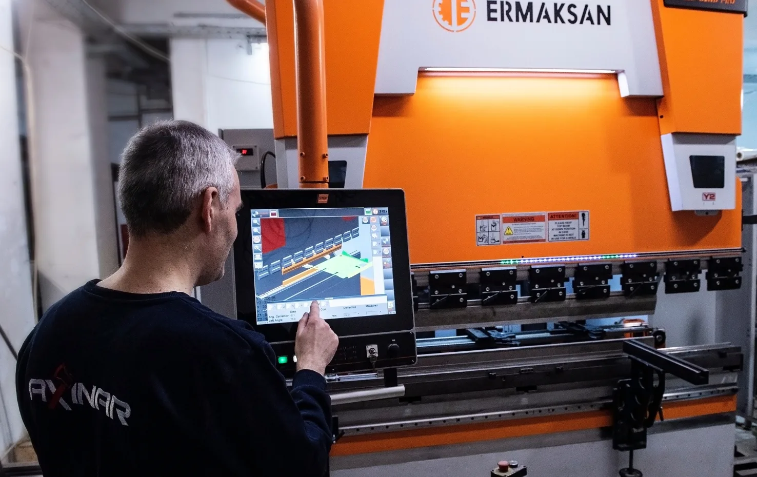 Axinar technician operating automated industrial machine via touch interface