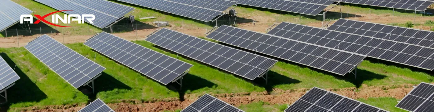 Panoramic view of AXINAR solar farm with rows of ground-mounted panels.