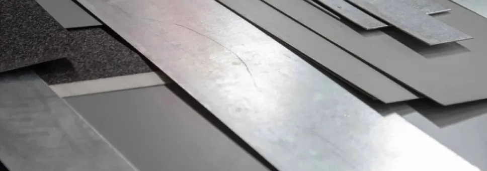 Stack of metal sheets ready for laser cutting at Axinar. Includes galvanized, aluminum, and steel materials in different sizes.