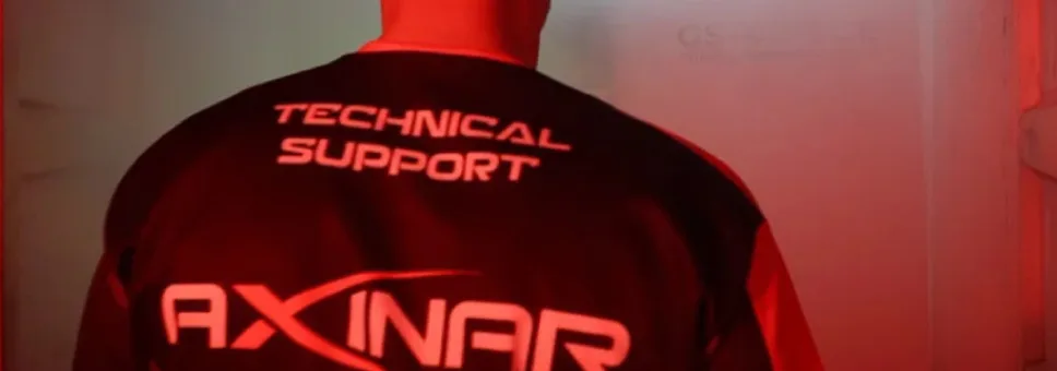 Μέλος της τεχνικής υποστήριξης της Axinar εισέρχεται στον χώρο κατεργασίας μετάλλου. Φορά στολή με το λογότυπο της εταιρείας.